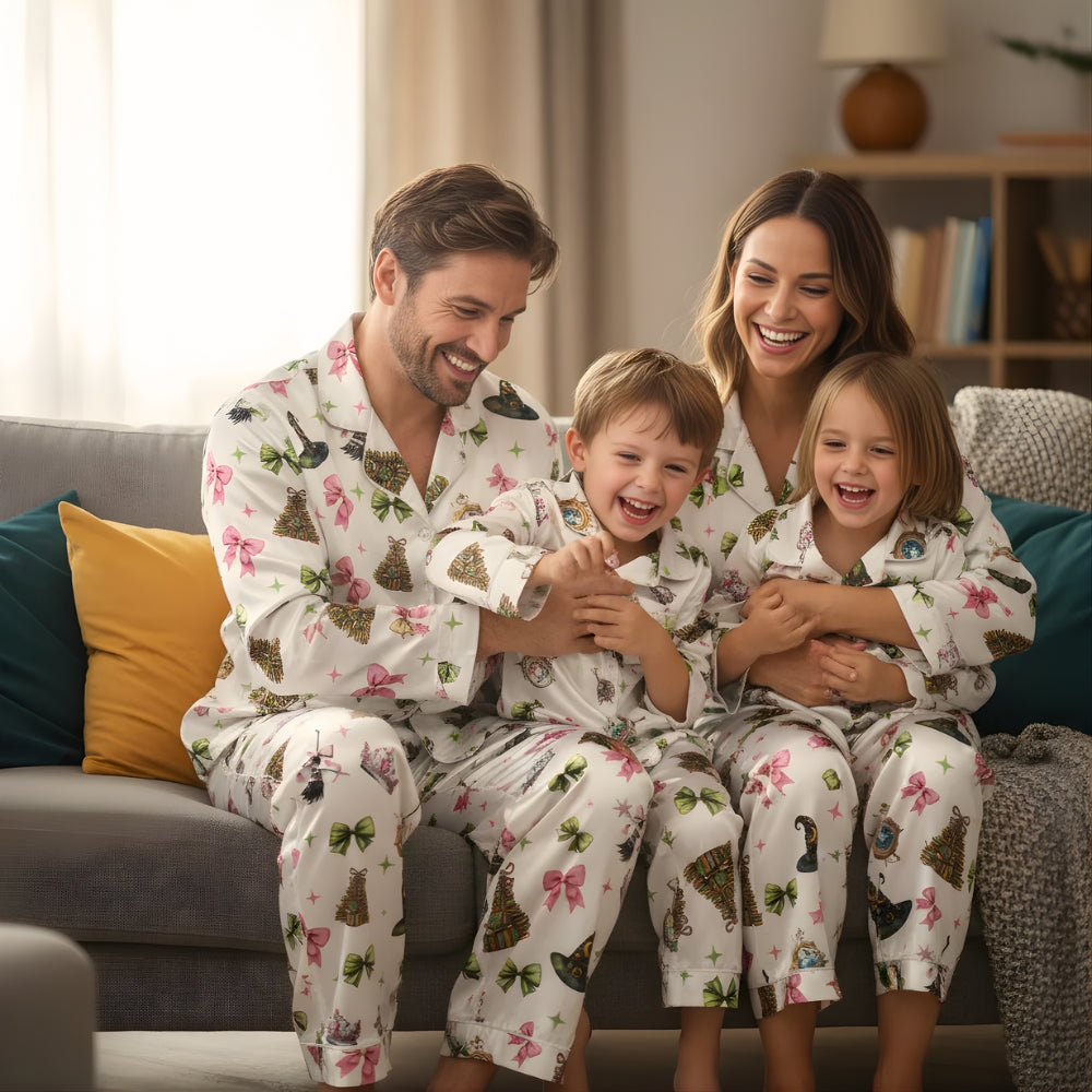 Family of four wearing matching pajamas with coquettish Wicked-themed details sitting on a couch in a cozy living room.